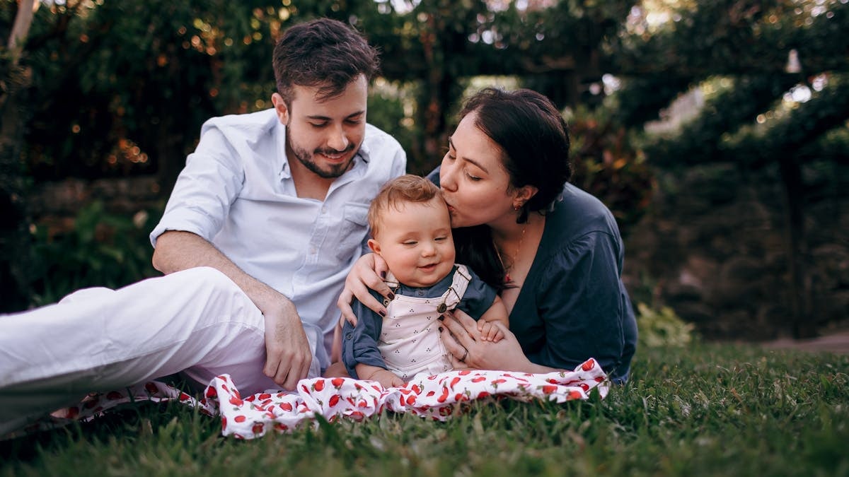 Family outdoor bonding with parents and a baby on a sunny day.
